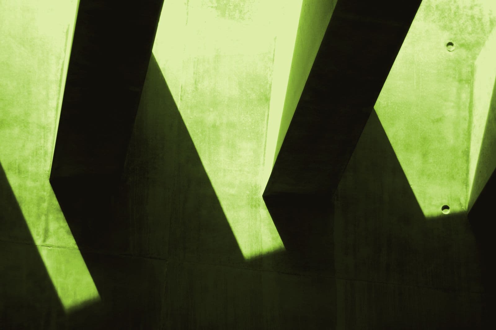 Hard shadows falling across a concrete wall